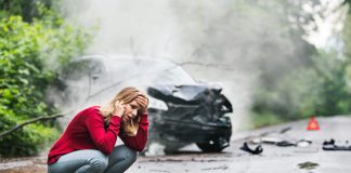 Woman making a phone call after a car accident