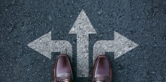 tanding on road with three direction arrow choices