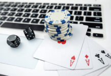 Business online poker games with laptop two black dice playing card and casino chips.