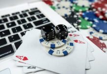 Online poker with laptop playing card chips and dice.