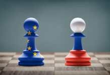 European Union and Russia conflict. Flags on chess pawns on a chess board.