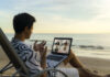 business man having remote video conference call with his business team at the beach during vacation