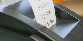 Receipt printer prints text big sale. Close-up, side view