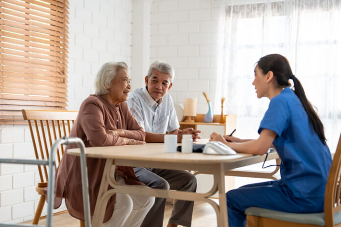 Asian caregiver nurse examine senior couple patient at home together