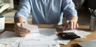Young skilled man analyzing utilities household bills or taxes