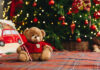 Teddy bear on bed with pillows for Christmas decoration close up