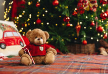 Teddy bear on bed with pillows for Christmas decoration close up