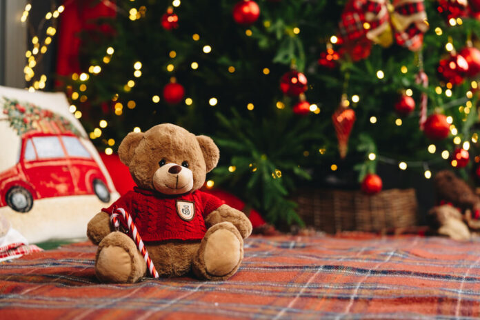 Teddy bear on bed with pillows for Christmas decoration close up