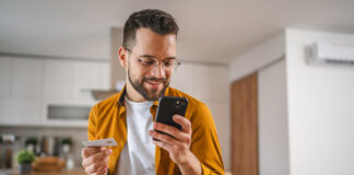 Man holding credit or debit card making online purchase