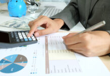 Business woman hold pen with calculator