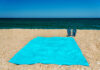 Blue sandal flip flop and towel on yellow sand