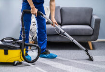 Person Cleaning Carpet With Vacuum Cleaner