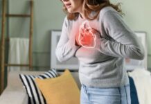 Young woman pressing on chest with painful expression