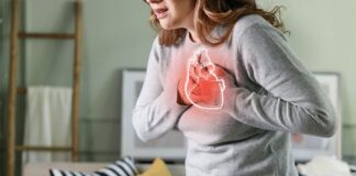 Young woman pressing on chest with painful expression