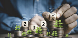 Businessman hand flipping wooden block cube from 2024 to 2025 on coins stacking for business budget planing and investment growth of new year