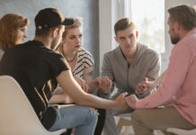 Group of teenagers talking with addiction counselor