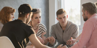 Group of teenagers talking with addiction counselor