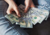 Woman counting new modern hundred dollar bills