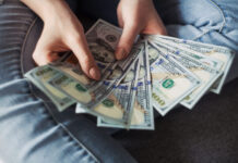 Woman counting new modern hundred dollar bills