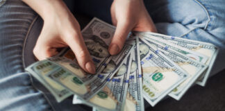 Woman counting new modern hundred dollar bills