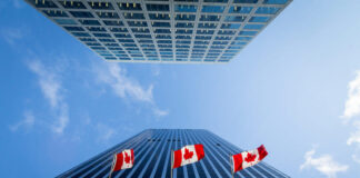 Three Canadian flags in front of a business building in Ottawa, Ontario, Canada.