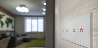 A white modern light switch on a white wall