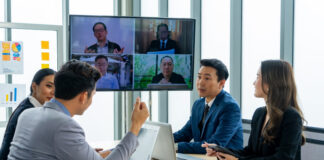 Executive business teamwork conference call to colleagues using technology online video chat on-screen monitor in a meeting room