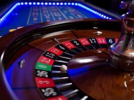 A roulette table with blue LED lights around the edge taken with a shallow depth of field.