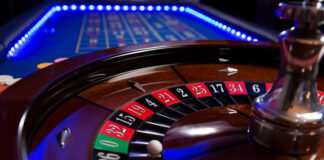 A roulette table with blue LED lights around the edge taken with a shallow depth of field.