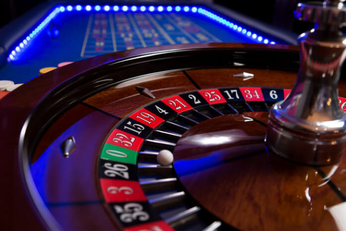 A roulette table with blue LED lights around the edge taken with a shallow depth of field.