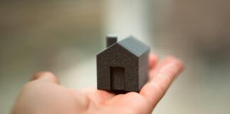 Hand holding small house
