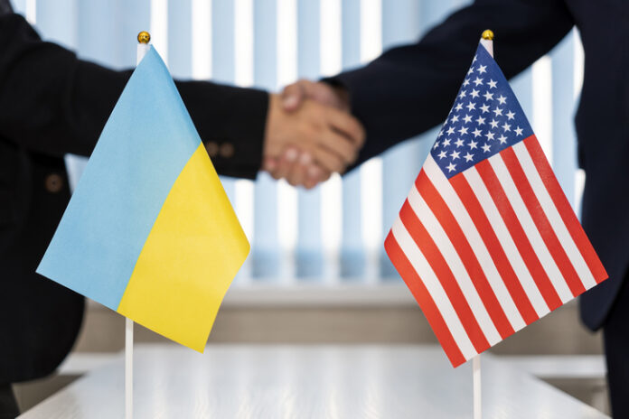 Political flags of Ukraine and United States of America on table in international negotiation room