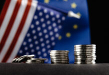 Money of the United States and Europe and two Flags on a dark background