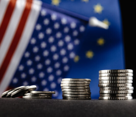 Money of the United States and Europe and two Flags on a dark background