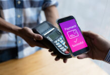 Close-up of a customer paying for goods with a mobile app on the counter.