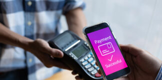 Close-up of a customer paying for goods with a mobile app on the counter.