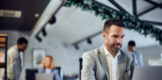An elegantly dressed man working in the co-working space, using a laptop