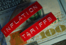 Red Tariffs and Inflation labels on a hundred dollar bill