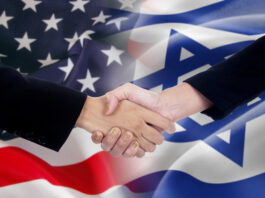 Two businesspeople shaking hands after good deal in front of the the american and israel flags