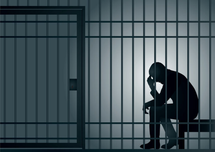 man imprisoned in a cell