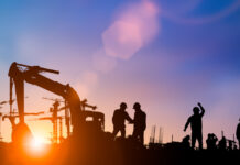 Silhouette of engineer and construction team working at site over blurred background for industry background with Light fair.