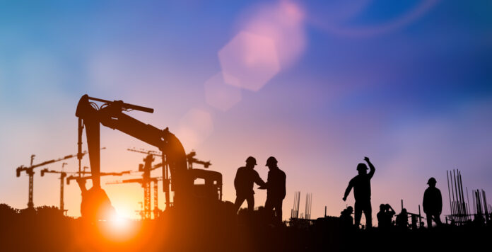 Silhouette of engineer and construction team working at site over blurred background for industry background with Light fair.