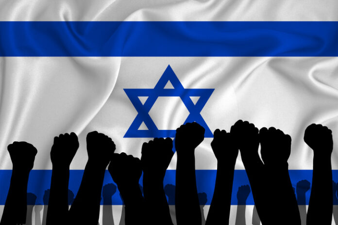 Silhouette of raised arms and clenched fists on the background of the flag of Israel.