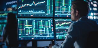 Trader analyzing stock charts on screens