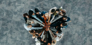 A diverse business group standing in a heart formation, symbolizing unity, teamwork, and collaboration.