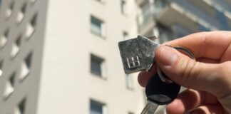 Woman holds key against a multi-storey residential area