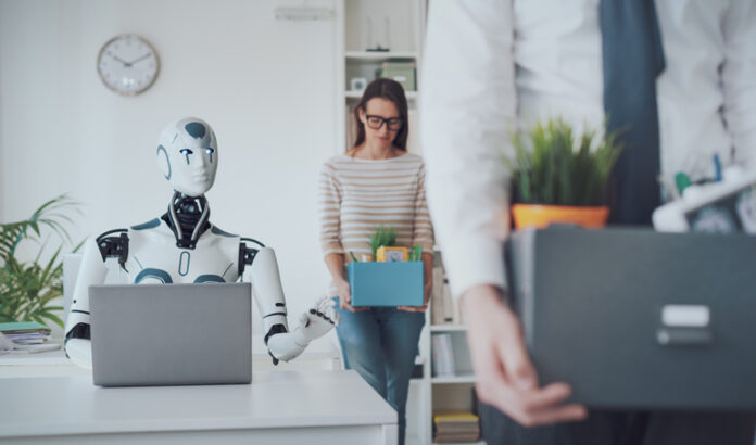 Dismissed business people packing their belongings and leaving the office, a robot is sitting at the desk and working