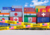 Shipping containers adorned with global flags, barricaded by US Tariffs tape