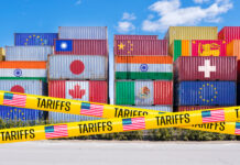 Shipping containers adorned with global flags, barricaded by US Tariffs tape