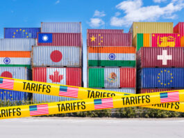 Shipping containers adorned with global flags, barricaded by US Tariffs tape